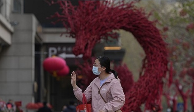 2024년 4월 9일 베이징의 한 음식점 앞에서 한 여성이 조각상을 보고 있다. 사진=AP/연합뉴스