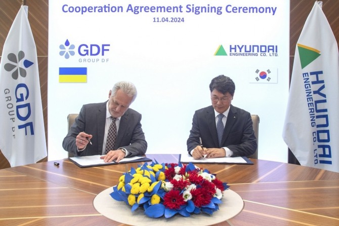 홍현성 현대엔지니어링 대표이사(오른쪽)와 드미트로 피르타시 그룹 DF 이사회 의장이 우크라이나 서부에 대규모 석유화학단지 개발을 위한 업무협약서에 서명하고 있다.  사진=그룹DF