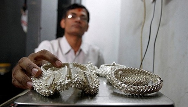 2011년 4월27일, 인도 서부의 아메다바드 시내 상인이 자신의 가게 안에서 은 장신구를 저울에 올려 보고 있다.     사진=로이터/연합뉴스