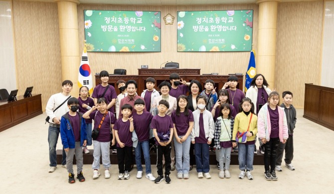 안산시의회가 지난 24일 정치초등학교 학생들을 대상으로 의회 견학 프로그램을 운영했다. 사진은 이날 본회의장에서 기념촬영에 임하고 있는 의원들과 정지초 학생들의 모습. 사진=안산시의회