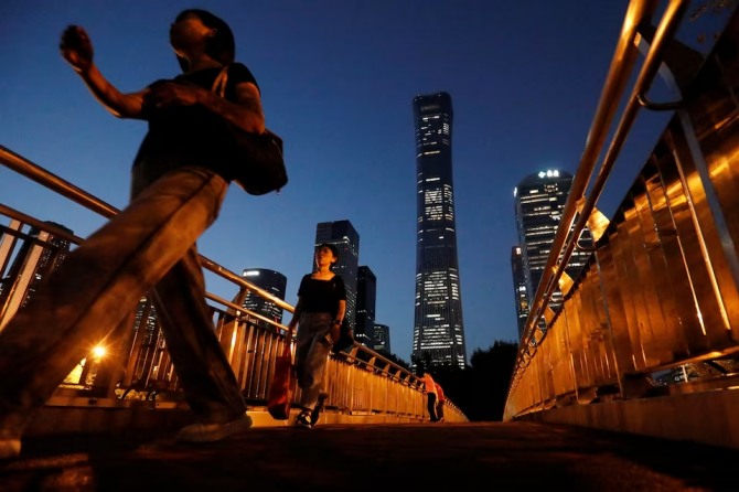 중국 기업들이 러시아 결제에 어려움을 겪고 있다. 2023년 8월 베이징 중심업무지구의 고층 빌딩 근처 육교 위를 보행자들이 걷고 있다. 사진=로이터