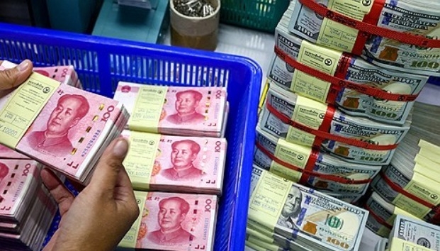 태국 방콕의 카시콘은행에서 직원이 미국 달러 지폐 옆에 있는  중국의 위안화를 살피고 있다.  사진=로이터/연합뉴스
