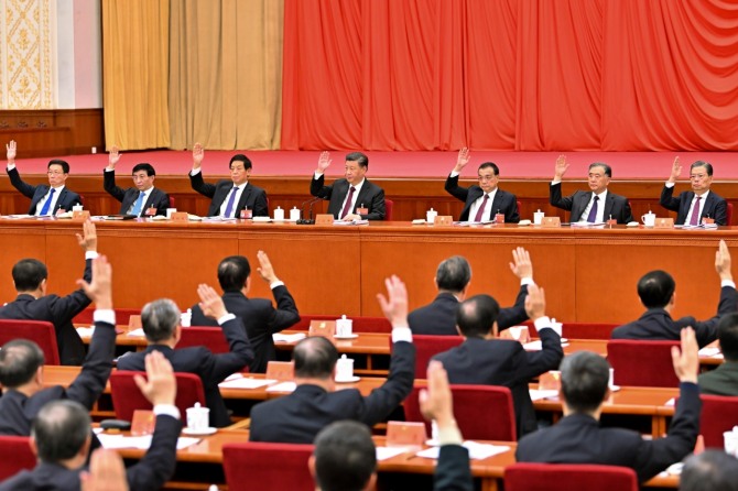 시진핑(가운데) 중국 국가주석이 지난 11일 중국 베이징에서 열린 중국 공산당 중앙위원회 6차 전체회의 '6중전회'에 참석해 손을 들어 안건을 의결하고 있다. 사진=뉴시스