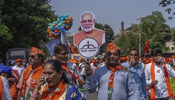 2024년 4월 29일 인도 뭄바이에서 총선을 앞두고 지지자들이 나렌드라 모디 총리의 사진을 든 채 걷고 있다. 사진=AP/연합뉴스   