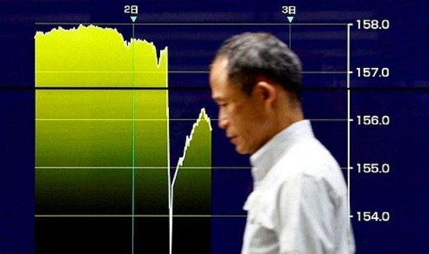 2024년 5월 2일 한 남성이 일본 당국의 개입이 추정되며 일본 엔화 환율이 미국 달러 대비 급등한 것을 보여주는 그래프가 표시된 화면 옆을 지나가고 있다. 사진=로이터/연합뉴스