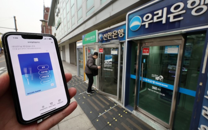 서울 시내의 한 ATM 부스 앞에서 모바일뱅킹 앱을 구동하는 모습. 사진=뉴시스