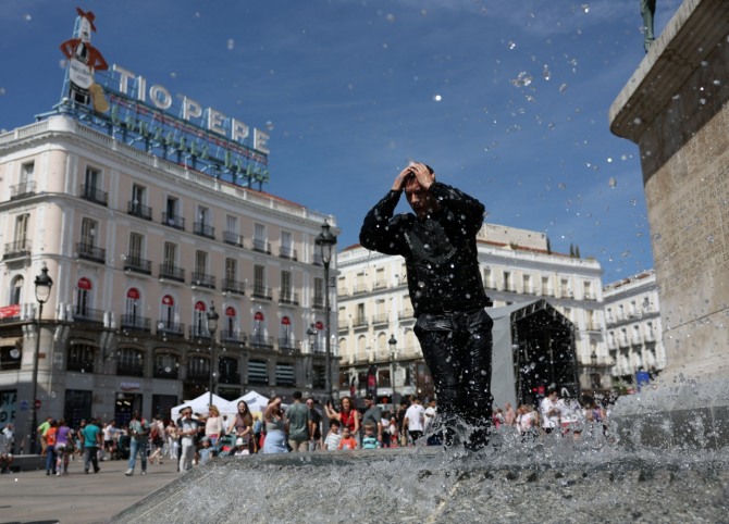 2024년 5월 11일 스페인 마드리드에서 기온이 치솟은 가운데 한 거리 공연자가 분수대에서 더위를 식히고 있다. 사진=로이터