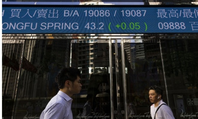 보행자들이 2023년 6월29일 홍콩 증권거래소 앞의 전자 스크린 시세판 앞을 지나가고 있다.     사진=AP/뉴시스