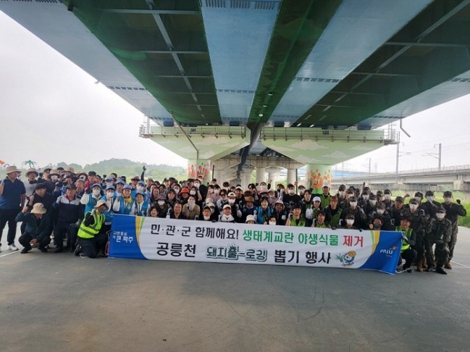 공릉천 일대 생태계교란 야생식물 제거 활동 후 참가자들이 기념사진을 촬영하고 있다. 사진=파주시 