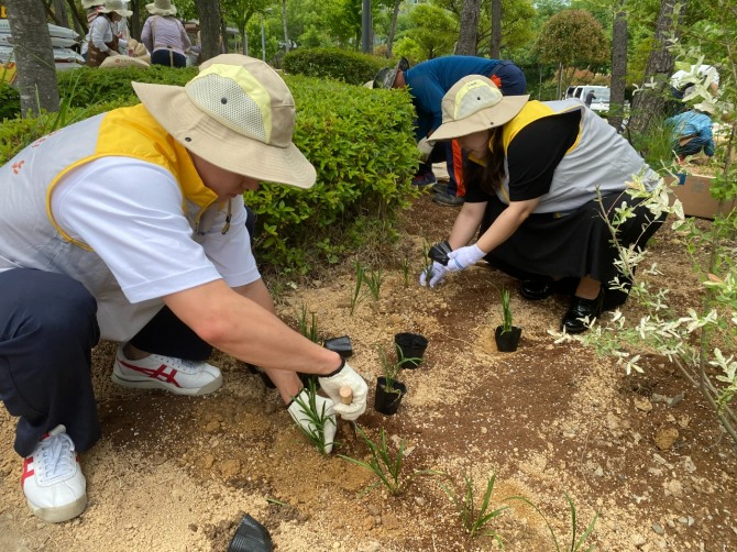 동심원 조성을 위해 동서발전 직원들이 꽃을 심고 있다  /사진=한국동서발전