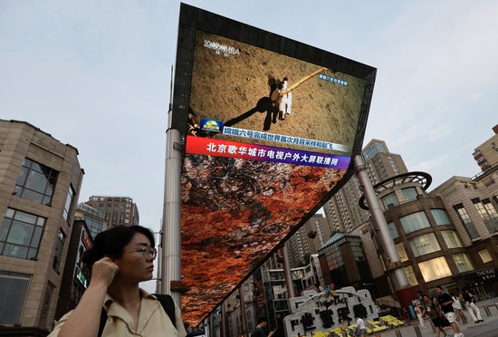 지난 4일 중국 베이징에서 달 뒷면에서 샘플을 수집하는 중국 창어 6호 달 탐사선의 뉴스 영상이 대형 화면에 나오고 있다. 사진=로이터