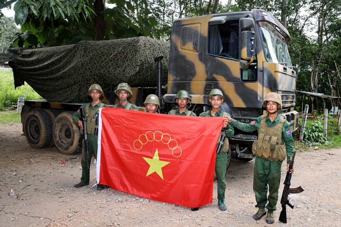 지난해 11월 미얀마민족민주동맹군(MNDAA) 소속 무장대원들이 샨주 쿤룽 타운십에서 탈취한 군용 차량을 배경으로 MNDAA 깃발과 함께 포즈를 취하고 있다. MNDAA는 소수민족 군대인 아라칸군(AA), 타앙민족해방군(TNLA)과 '형제 동맹'을 맺고 지난달 말부터 샨주에서 군부 독재 타도를 목표로 미얀마군과 교전을 벌이고 있다. '형제 동맹'은 전국적으로 공세를 확대할 것이라고 밝혔다. 사진=AP/뉴시스