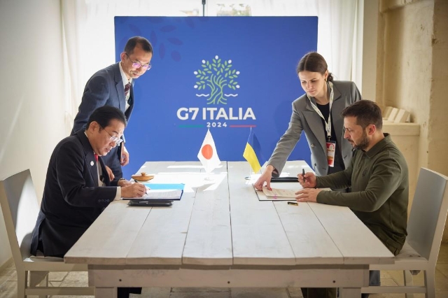 기시다 후미오 일본 총리(왼쪽)가 지난 13일(현지시각) 이탈리아에서 열린 G7 정상회의를 계기로 볼로디미르 젤렌스키 우크라이나 대통령(오른쪽)과 회동, 양자 안보협정 문서에 서명하고 있다. 사진=우크라이나 대통령실 제공