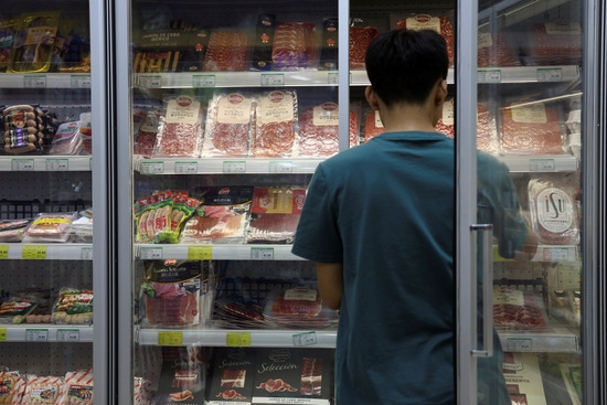 지난 13일 중국 베이징의 한 슈퍼마켓에서 직원이 돼지고기 및 기타 육류 제품이 진열된 냉동고를  정리하고 있다. 사진=로이터