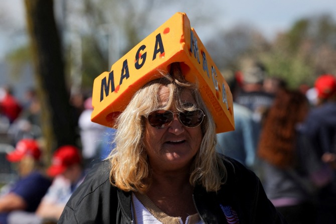 공화당 대선 후보이자 전 미국 대통령인 도널드 트럼프의 지지자가 지난 5월 1일 미국 위스콘신주 워키샤에서 열린 선거 행사에서 MAGA(미국을 다시 위대하게) 슬로건이 쓰인 모자를 쓴 채 트럼프의 연설을 지켜보고 있다. 사진=로이터