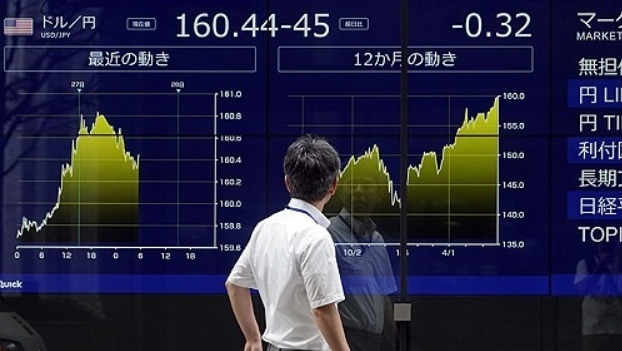 2024년 6월 27일 일본 도쿄에서 일본 엔화에 대한 미국 달러의 환율을 보여주는 외화 표시판을 지나가는 행인이 보고 있다. 사진=EPA/연합뉴스