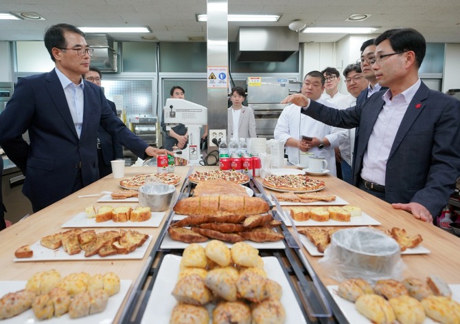 신세계푸드 R&D 센터에서 신세계푸드 공병천 베이커리 본부장(오른쪽)과 남해군청 장충남 군수가 ‘남해 마늘’ 활용 베이커리 제품들을 시식해 보고 있다. / 사진=신세계푸드