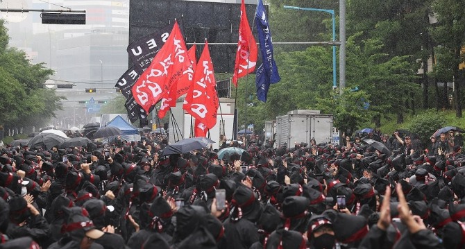 8일 오전 경기도 화성시 삼성전자 화성사업장 앞에서 열린 전국삼성전자노동조합 총파업 결의대회에서 조합원들이 입장하는 깃발을 보며 박수치고 있다.  사진=연합뉴스