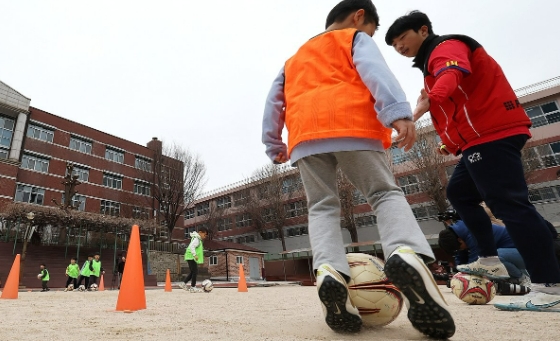 지난 3월 서울 아현초등학교 '늘봄학교' 프로그램 축구에 참여한 학생들이 교사와 다양한 기술을 체험하고 있다. 사진=연합뉴스 