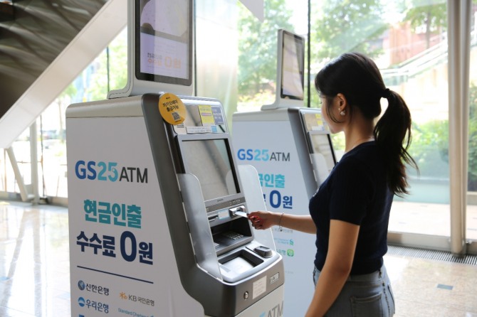 고객이 GS25의 ATM에서 트래블월렛카드를 꺼내고 있다. / 사진=GS25