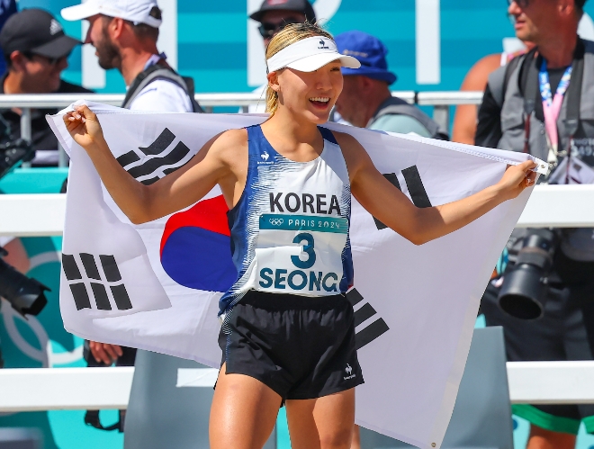 11일(한국시각) 프랑스 베르사유 궁전에서 열린 2024 파리올림픽 근대5종 여자 결승전 레이저런에서 성승민이 질주를 마친 뒤 태극기를 두르고 웃고 있다. 그는 이 종목에서 동메달을 획득했다. 사진=연합뉴스