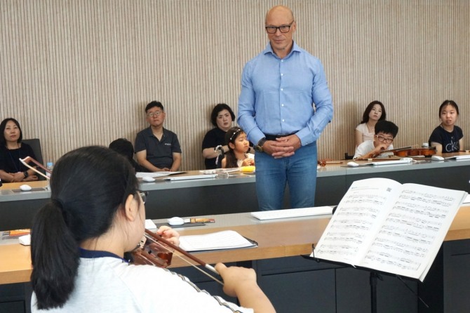 세계적인 첼리스트 아틸라 파스토르가 상상인증권 본사에서 휠체어 아동의 연주를 집중해서 듣고 있다. 사진=상상인그룹