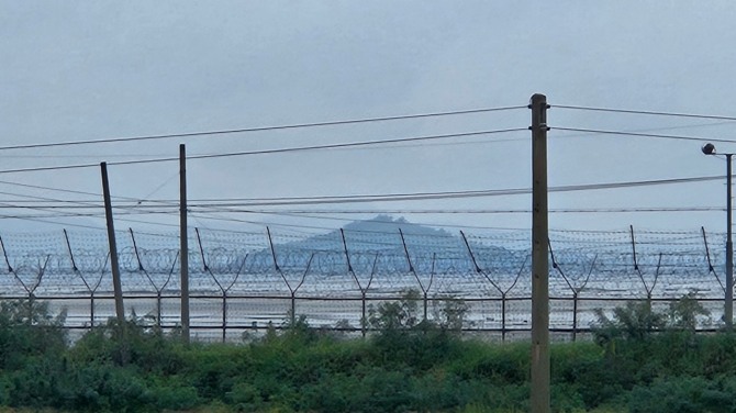 접경지역인 교동도에서 바라본 철책너머 예성강과 북한이 보인다. 인근지역인 교동면 주민들은 밤 낮 북한에서 소름끼치는 괴소음을 들으며 스트레스를 받고 있다.  주민 A씨는 몇 달 전까지는 평온하던 마을 이였는데 요즘엔 괴소음을 들으며 산 다는게 불공평하고 엤날처럼 돌아갔으면 한다고 말했다.    사진=유영재 기자 