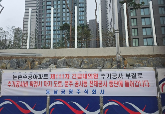 일부 시공사와 조합간 공사비 갈등으로 공사가 중단되면서 올림픽파크포레온의 준공 승인에 적신호가 켜졌다. 올림픽파크포레온 공사 현장에 붙어있는 공사 중단 플래카드. 사진=문용균 글로벌이코노믹 기자 