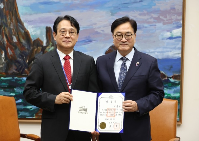 31일 국회 의장실에서 공영방송 지배구조 개선을 위해 열린 '방송법 범국민협의회 준비모임'에서 우원식 의장(오른쪽)이 준비위원장인 이준웅 서울대 언론정보학과 교수에게 위촉장을 전달한 뒤 포즈를 취하고 있다. 사진=연합뉴스