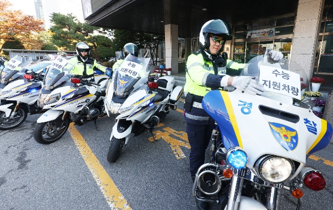 경기도 수원시 영통구 수원남부경찰서에서 경찰관들이 수능 특별 교통관리에 사용될 경찰 오토바이와 순찰차에 안내문을 부착하고 있다. 사진=연합뉴스 