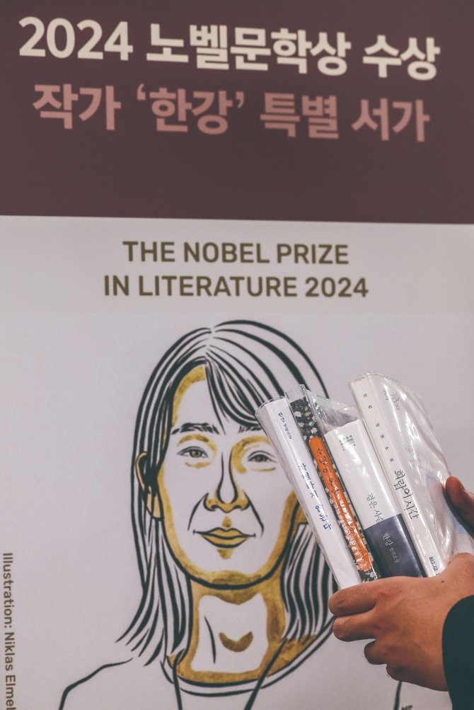 지난 10월 21일 서울 서초구 국립중앙도서관 본관 문학실에 마련된 한강 특별 서가를 찾은 시민이 한강 작가의 책을 들고 있다. 사진=뉴시스