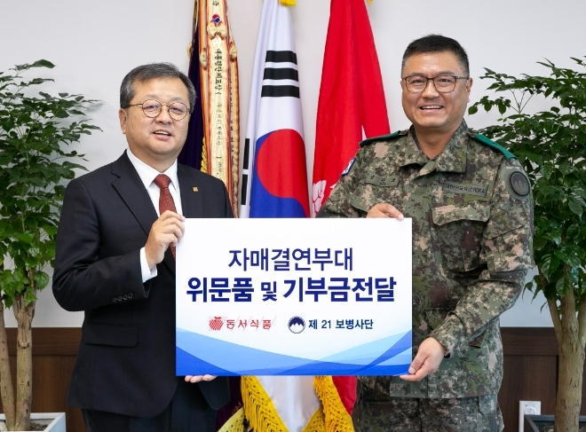 지난 2023년 12월 1일 강원도 양구군 제21보병사단에서 진행된 '동서식품 자매결연 부대 기부금 및 위문품 전달식'에서 동서식품 김광수 사장(왼쪽)과 당시 제21보병사단 남진오 사단장이 기념사진을 찍고 있다.  /사진=동서식품