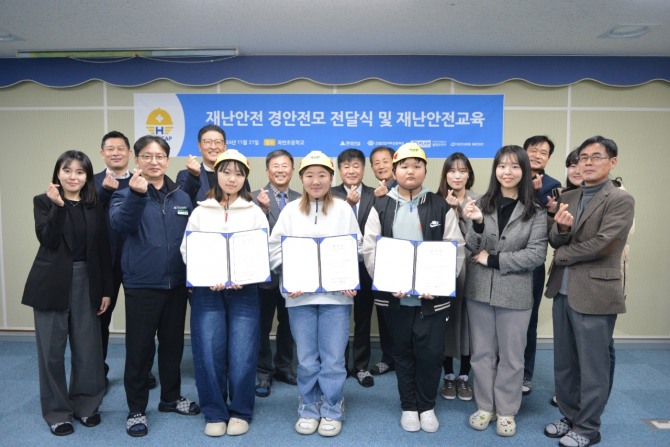 지나 21일 현대건설이 울진 죽변초등학교에서 진행한 ‘안전모 전달식 및 재난안전교육’ 행사 후 관계자들과 학생들이 기념촬영을 하고 있다. 사진=현대건설