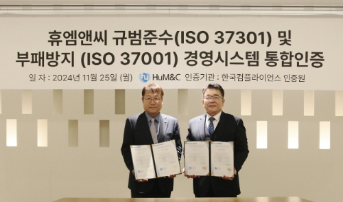 25일 휴엠앤씨 판교 본사에서 열린 'ISO37301·37001 인증 수여식'에서 참석자들이 기념 촬영을 하고 있다. 왼쪽부터 김준철 휴엠앤씨 대표, 이원기 한국컴플라이언스인증원 원장. 사진=휴온스글로벌