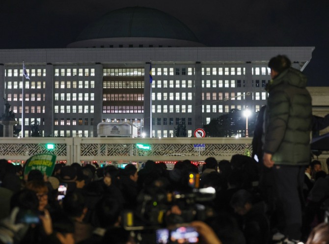 윤석열 대통령의 비상계엄 해제 요구 결의안이 국회 본회의에서 통과된 4일 새벽 서울 영등포구 국회 정문 앞에서 시민들이 윤석열 대통령 퇴진 촉구 구호를 외치고 있다. 사진=뉴시스