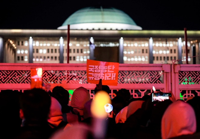 지난 7일 서울 영등포구 국회 앞에서 열린 집회에서 시민들이 윤석열 대통령 탄핵안 개표 결과를 확인한 뒤 피켓을 들고 있다. 사진=뉴시스 