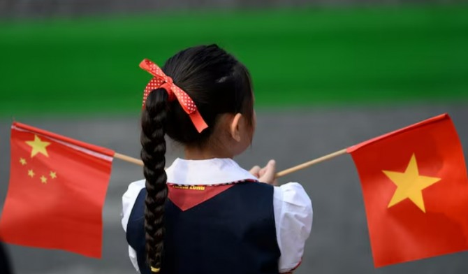 베트남 학생이 중국과 베트남 국기를 흔들고 있다.   사진=로이터