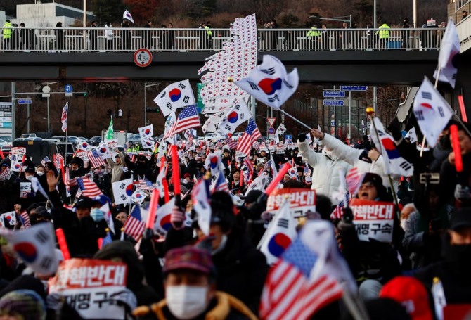 지난달 31일(현지 시각) 서울 용산구 소재 대통령 관저 앞에서 국회로부터 탄핵 소추돼 직무가 정지된 윤석열 대통령 지지자들이 태극기와 미국 성조기를 흔들며 탄핵 반대 시위를 벌이고 있다. 사진=로이터