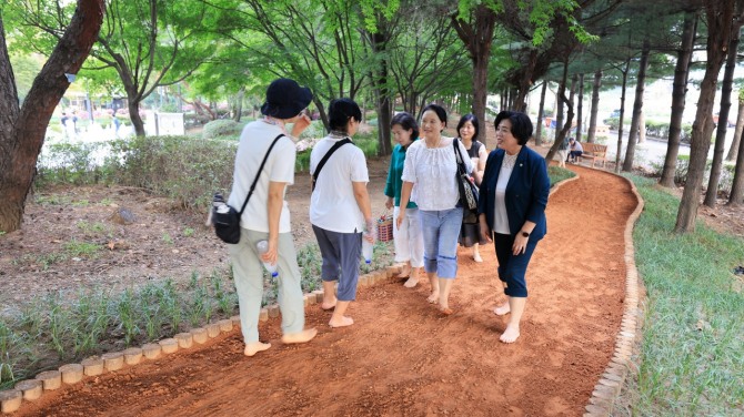 지난해 에어드리공원 환경조성사업으로 조성된 황톳길에서 신계용 과천시장과 시민들이 걷고 있다. 사진=과천시