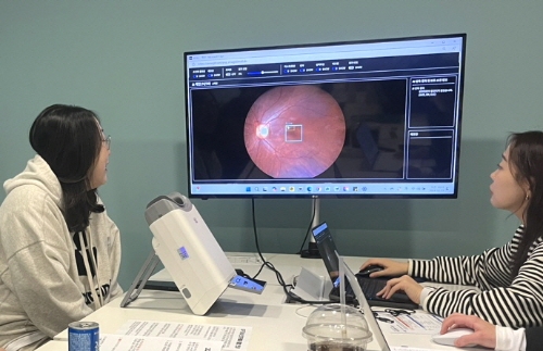대웅제약 임직원(왼쪽)이 AI 실명질환 진단 보조 솔루션 위스키와 안저카메라 옵티나 제네시스를 이용해 3대 실명질환 검사를 받은 후, AI 판독 결과를 확인하고 있다. 사진=대웅제약