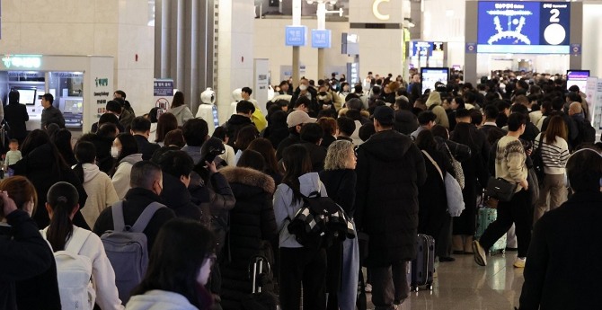 설 명절 연휴를 앞둔 23일 오전 인천국제공항 제1여객터미널 출국장에서 승객들이 탑승 수속을 위해 줄을 서고 있다. 사진=연합뉴스