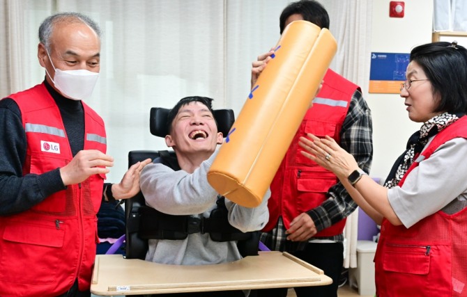 LG전자 '라이프스굿 봉사단' 인원들이 설 연휴를 앞둔 지난 23일 염리장애인주간보호센터를 찾아 이용 장애인들과 함께 윷놀이를 하며 즐거운 시간을 보내고 있다. 사진=LG전자