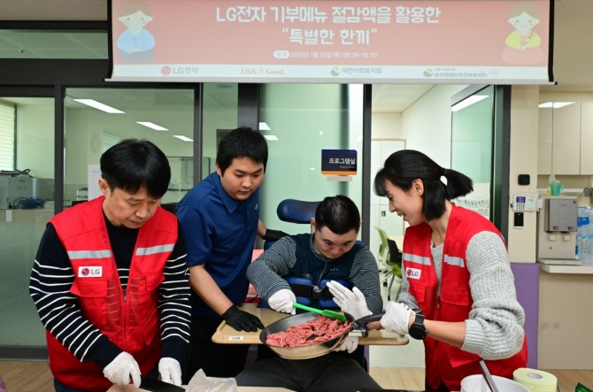 LG전자 '라이프스굿 봉사단' 인원들이 설 연휴를 앞둔 지난 23일 염리장애인주간보호센터를 찾아 이용 장애인들과 설 음식인 떡국을 함께 만들고 있다. 사진=LG전자