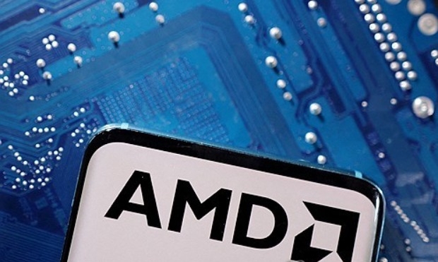 2023년 3월 6일 AMD 로고가 표시된 스마트폰이 컴퓨터 마더보드 위에 놓여있다. 사진=로이터/연합뉴스