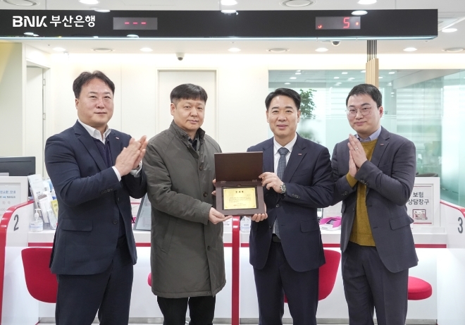 20일 김병기(오른쪽 두 번째) BNK부산은행 경영지원그룹장 등 관계자들이 일광지점에서 발생한 강도 미수 사건 용의자 검거에 도움을 준 시민 박천규(오른쪽 세 번째) 씨에게 ‘감사패’를 전달하고 기념 촬영을 하고 있다. 사진=부산은행