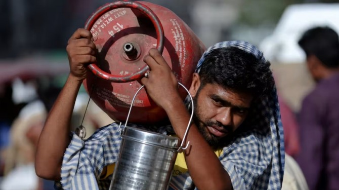 한 남자가 델리 구시가지에 있는 도매 시장에서 LPG 실린더를 어깨에 메고 있다. 사진=로이터