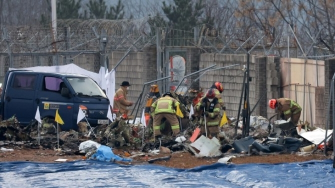 지난해 전남 무안국제공항에서 소방대원들이 전날 발생한 제주항공 여객기 충돌 폭발 사고 잔해를 수색하고 있다. 사진=뉴시스