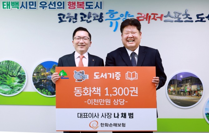 8일 오후 태백시청에서 열린 '지역활성화를 위한 동화책 기증식'에서 나채범 한화손해보험 대표이사(왼쪽)와 이상호 태백시장이 기증식에 참석하여 기념촬영을 하고 있다. 사진=한화손해보험 제공.
