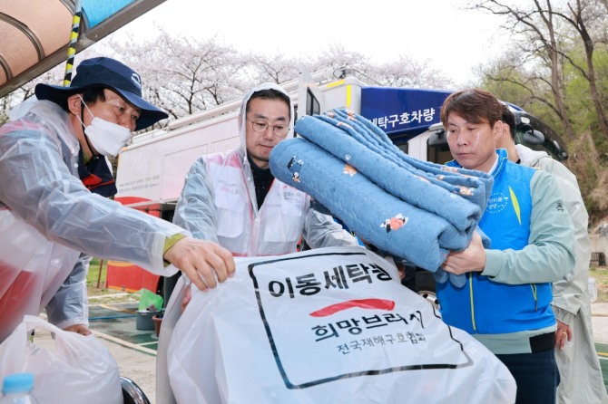 희망브리지 관계자와 봉사자가 광명사랑의집에서 세탁을 마친 침구를 정리하고 있다. /사진=희망브리지