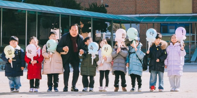 이권재 오산시장이 관내 초등학교를 방문해 입학장학금을 확대할 것을 약속한 후 학생들과 기념촬영을 하고 있다. 사진=오산시